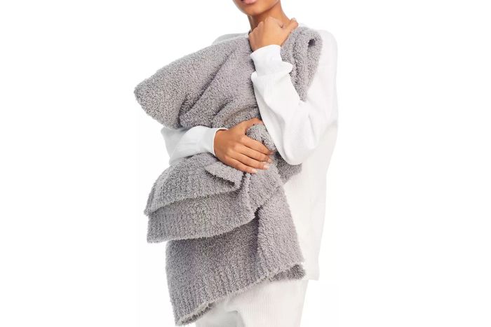 A person holding the Barefoot Dreams CozyChic Throw