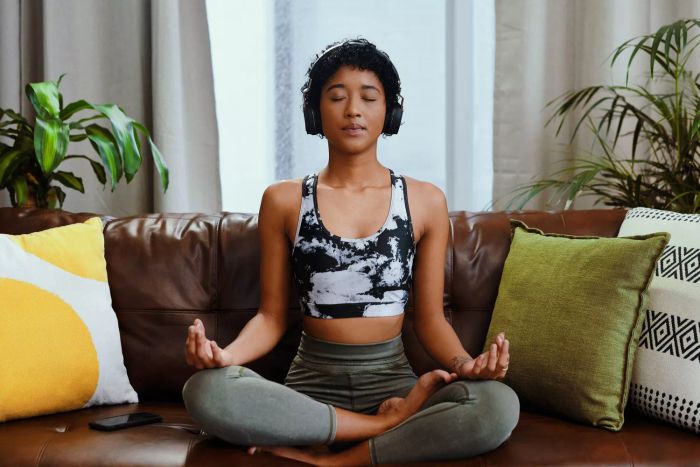 The top free meditation apps: A woman meditating in her living room.