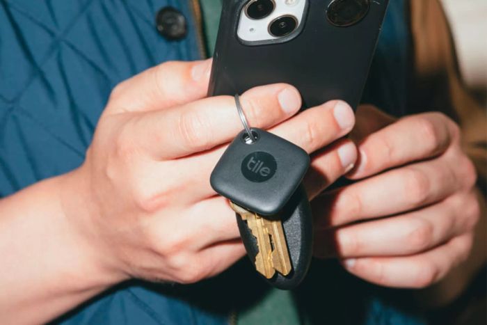A person attaching the Tile Mate Tracker to their keys