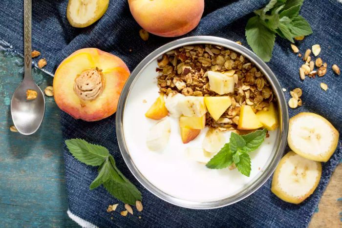 A healthy breakfast featuring muesli, fresh berries, yogurt, and seeds, placed on a rustic wooden surface – perfect for detox and nourishing your body.