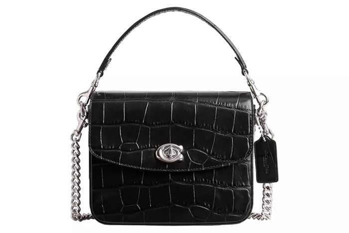 The Amazon Coach Women's Embossed Croc Cassie Crossbody is a sophisticated piece, combining the luxurious feel of embossed croc leather with the convenience of a crossbody bag design.
