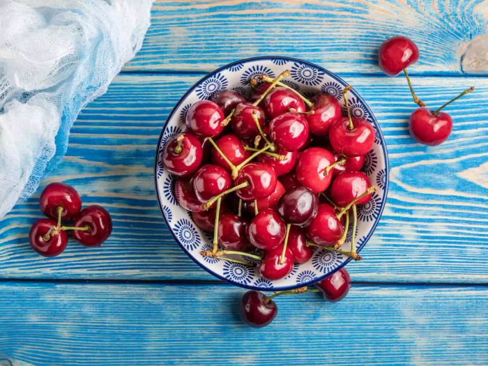 Fresh cherries in a blue bowl.