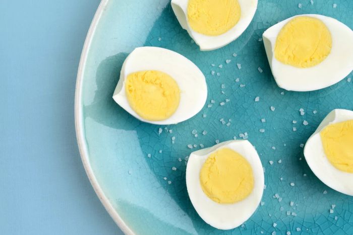 Hard boiled eggs on a turquoise plate with sprinkled salt