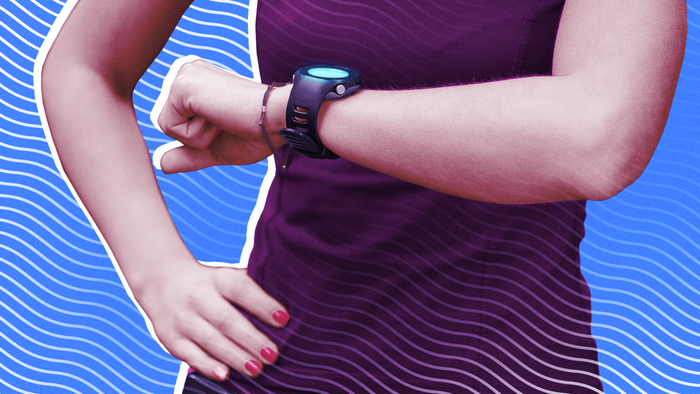 A woman dressed in athletic attire monitoring her fitness smartwatch