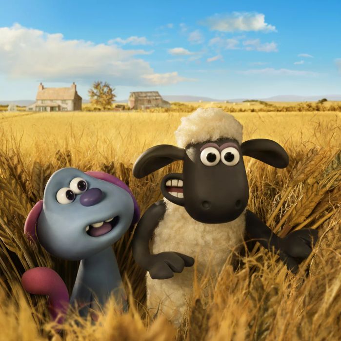 A sheep and a small blue dog-like creature standing in a hay field