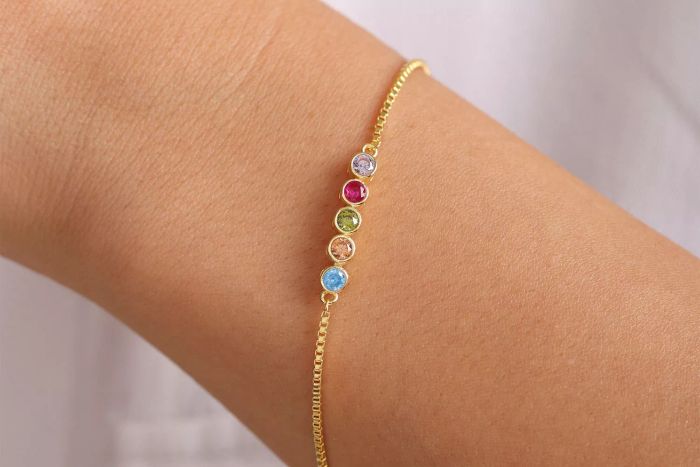 A person showcasing the Lusiva 14K Gold Birthstone Bracelet on their wrist.