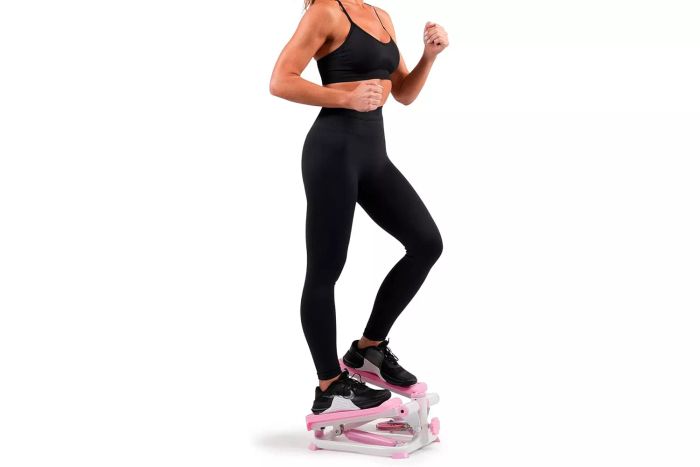 A person in sportswear using the Sunny Health and Fitness Mini Stepper.