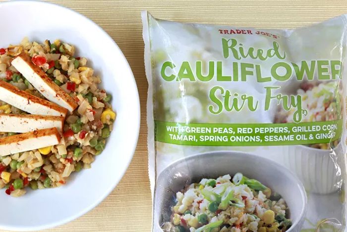 Trader Joe's Riced Cauliflower Stir-Fry package next to a plate of the cooked dish