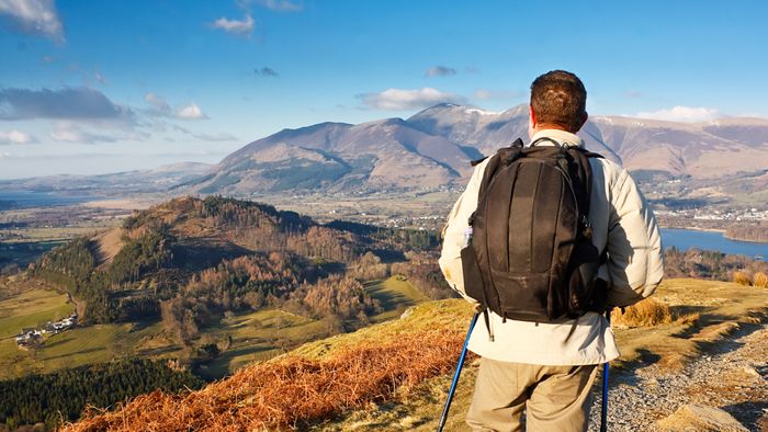 A person hiking up a mountain with a backpack on their back.