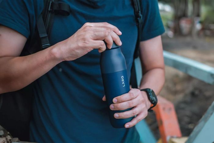 A close-up shot of someone opening the LARQ Bottle PureVis, showcasing its unique design and functionality.