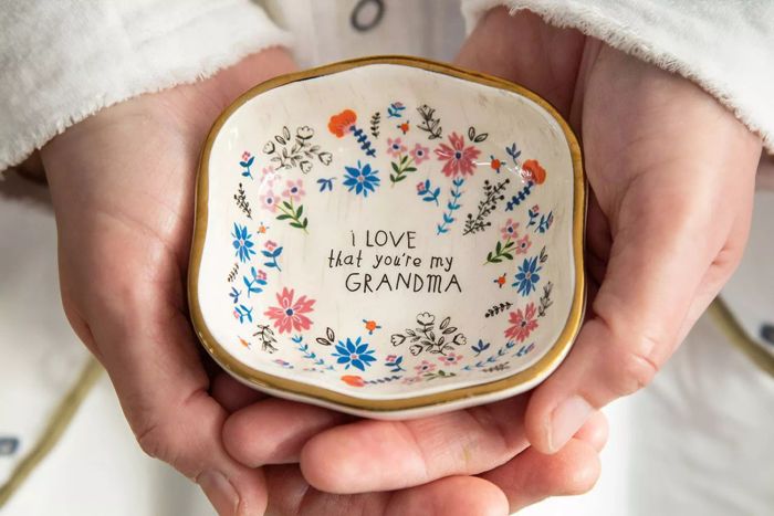 A person holding the Natural Life Antiqued Trinket Bowl Grandma.