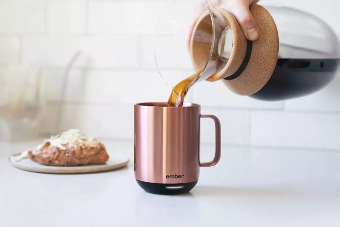 A close-up shot of someone pouring freshly brewed black coffee into the Ember Temperature Control Smart Mug 2, showcasing its elegant design.