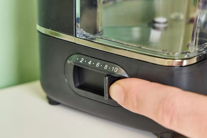 A finger adjusting a control on the Waterpik ION Professional Water Flosser