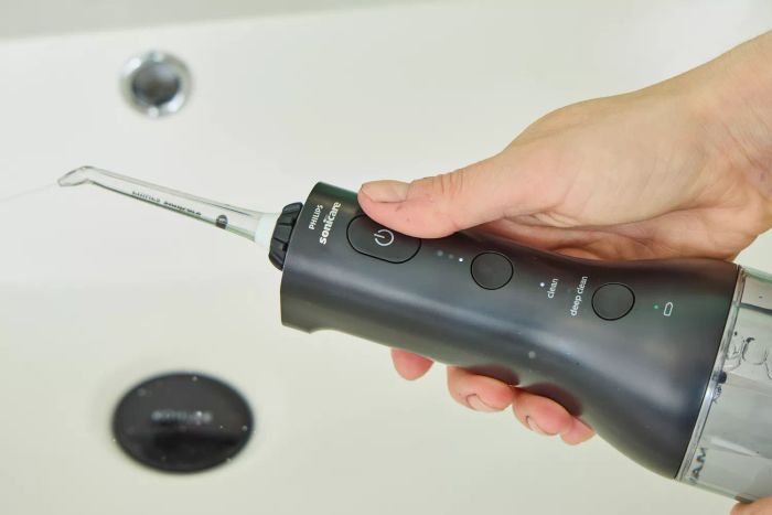 A hand adjusting a setting on the Philips Sonicare Cordless Power Flosser 3000