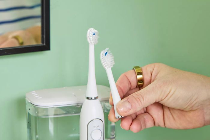 A hand gripping the head of the Waterpik Sonic-Fusion 2.0 Professional