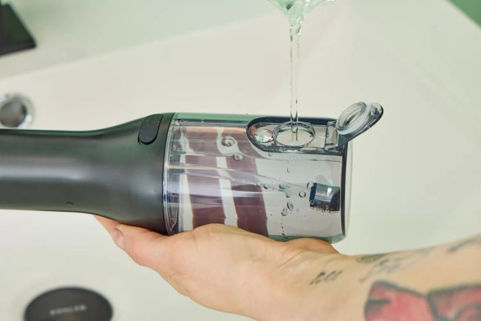 Someone filling the water reservoir of the Philips Sonicare Cordless Power Flosser 3000