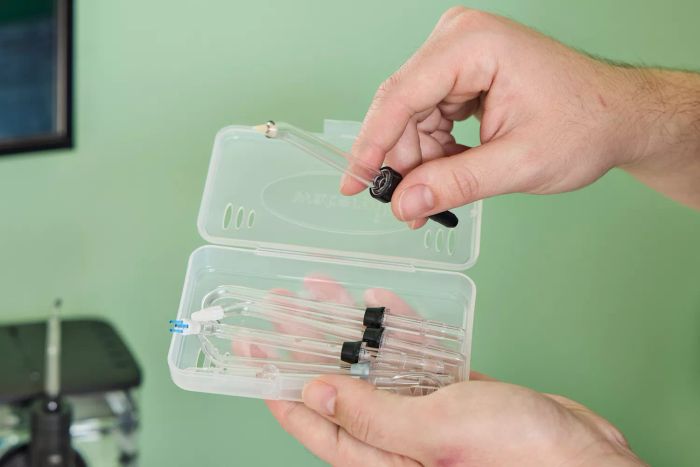 A hand removing a component of the Waterpik ION Professional Water Flosser from its storage case