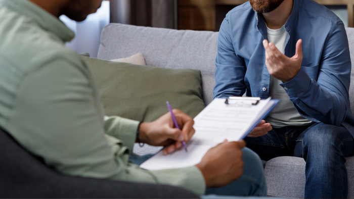 An image of two individuals conversing during a therapy session