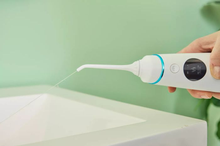 Water streaming from the Zima Dental Hydropod Smart Water Flosser into a sink