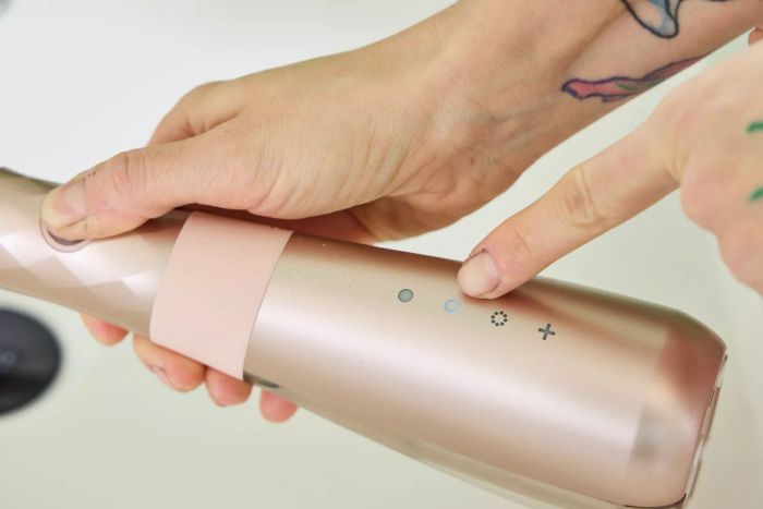 A finger indicating a light on the Burst Water Flosser