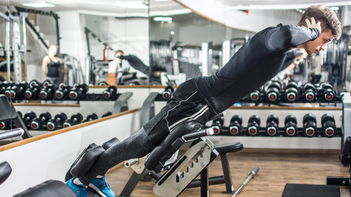 A person performing a back extension exercise at the gym
