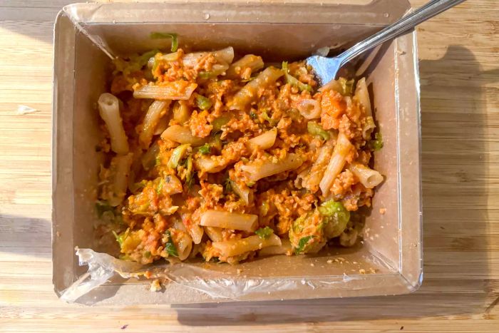 A person eating a pasta meal from the Splendid Spoon Meal Kit