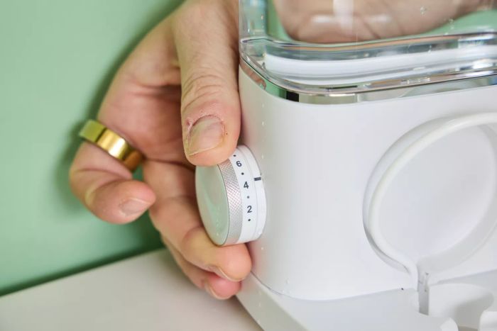 A person adjusting a dial on the Waterpik Sonic-Fusion 2.0 Professional