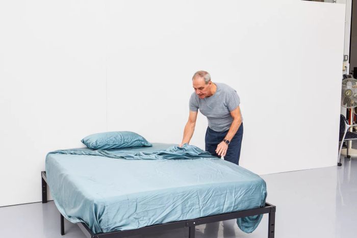 A person arranging the Colorado Home Co. Mulberry Silk Bed Sheets Set on a bed