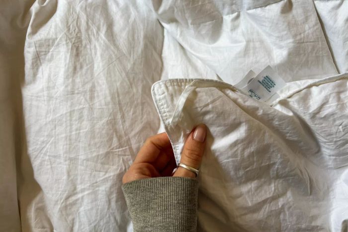 A person lightly touches the Avocado Down Duvet Insert