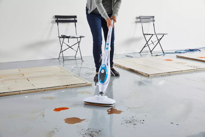 A person using the PurSteam 10-in-1 Steam Mop to clean multiple stains.