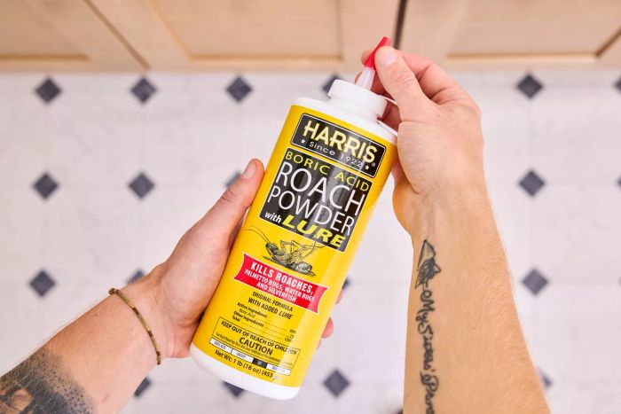 A hand twisting the cap off the Harris Boric Acid Roach Powder With Lure
