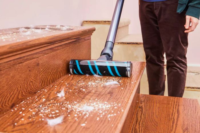 A person cleaning wooden stairs using the Samsung Jet 90 Vacuum