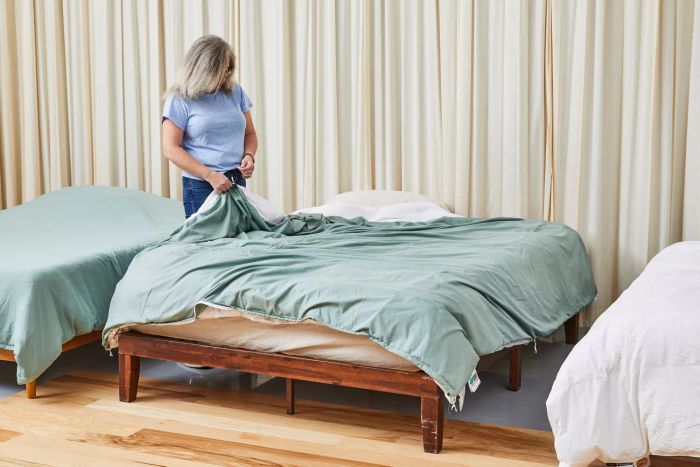 An individual holding the Egyptian Bedding Luxurious Queen Size Goose Down Feather Comforter