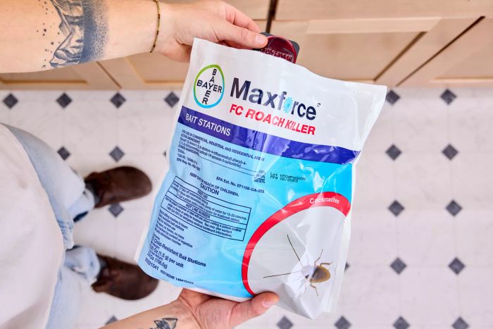 A person holding the packet of Maxforce FC Roach Killer Bait Stations while removing one from the bag