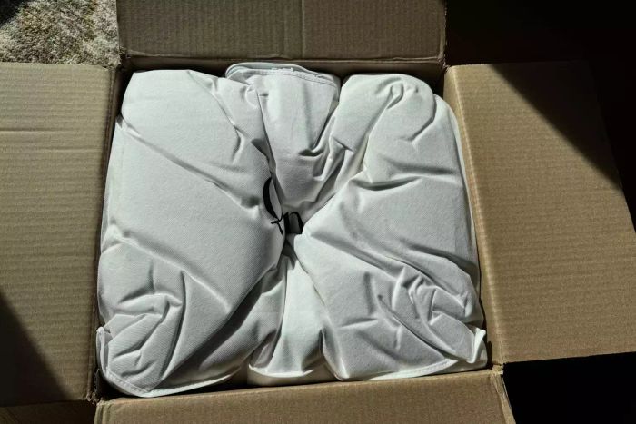 The Quince Ultra Warm Luxe Goose Down Comforter neatly folded inside a cardboard box.