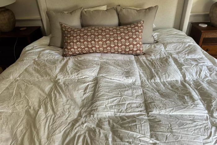 The Quince Ultra Warm Luxe Goose Down Comforter spread out on a bed.