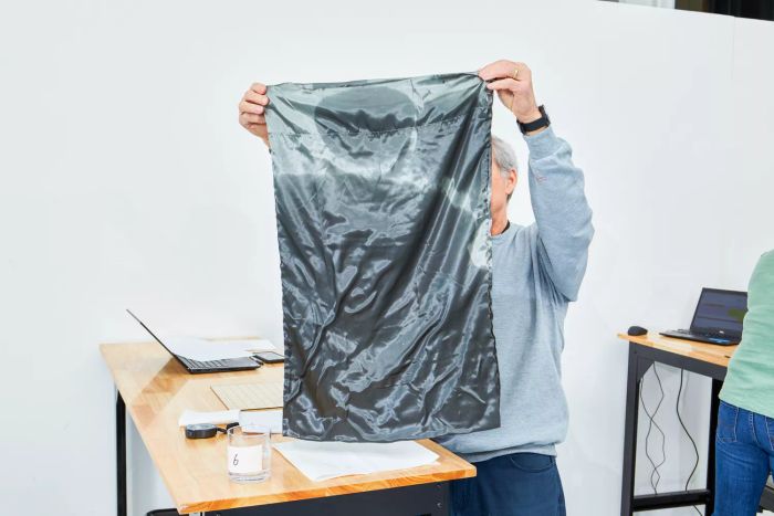 A person holding a Lanest Housing Silk Satin Sheets pillowcase soaked with water