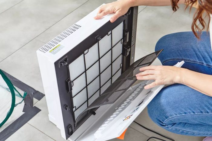 A person opening the rear panels of the Rabbit Air MinusA2 Ultra Quiet HEPA Air Purifier SPA-780A