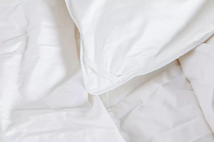 A detailed view of the corner of the Kassatex European White Goose Down Comforter, highlighting its fine craftsmanship.