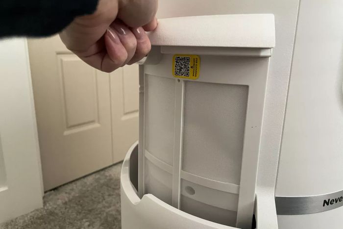 A person opening the filter compartment of the Shark NeverChange Air Purifier MAX