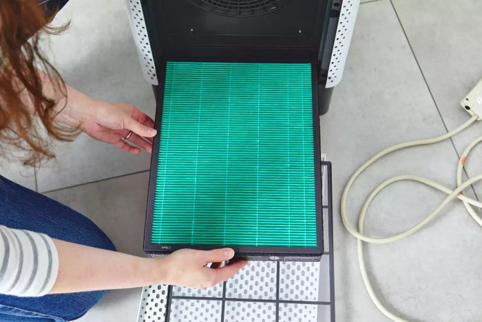A person removing a filter from the Coway Airmega 400S Smart Air Purifier