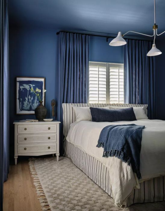 A bedroom bathed in rich blue tones.