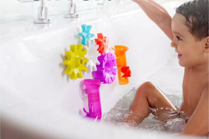 A child is enjoying playtime with the Boon Building Bath Toys Set