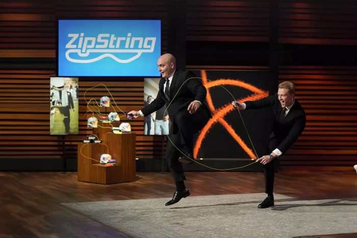 Two individuals in formal attire are using the Zipstring String Rope Launcher to enjoy jump rope