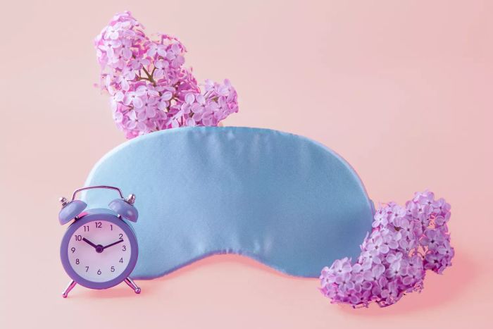 floral-patterned sleep mask beside a clock