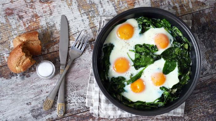 Eggs in a pan with spinach and other ingredients