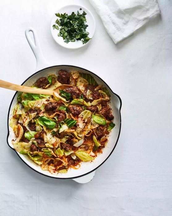 Beef and Cabbage Skillet Supper Served in a White Skillet With a Wooden Spoon for Serving