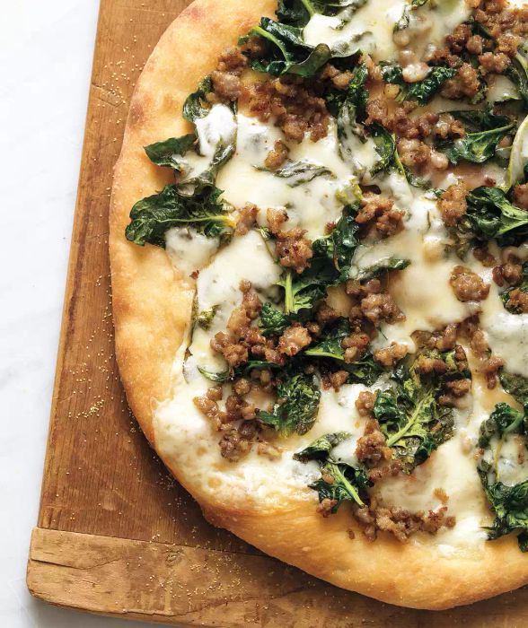 Sausage, Spinach, and Provolone Pizza on a Wooden Cutting Board