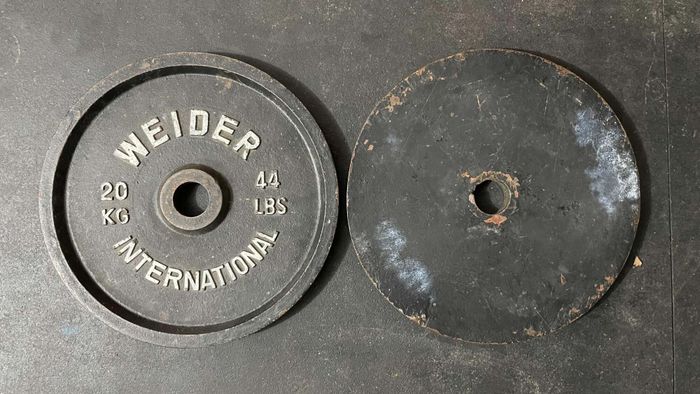 An iron plate (Weider International, 20kg/44lbs), with a smooth back surface.