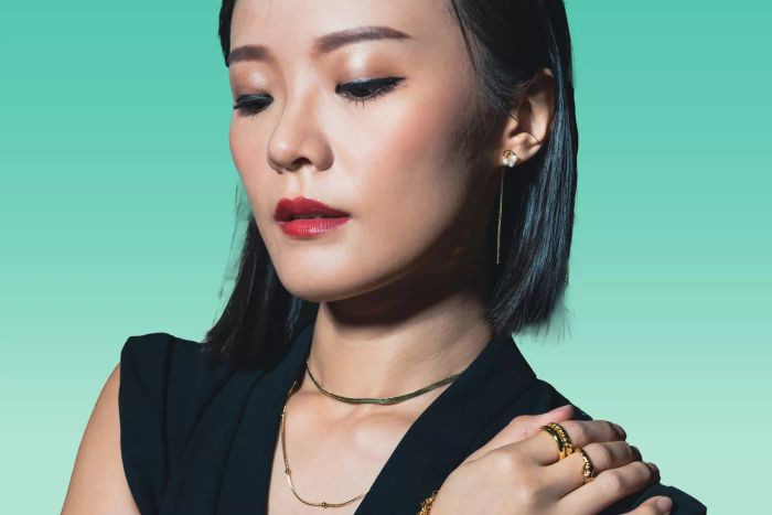 A woman showcasing a herringbone necklace.